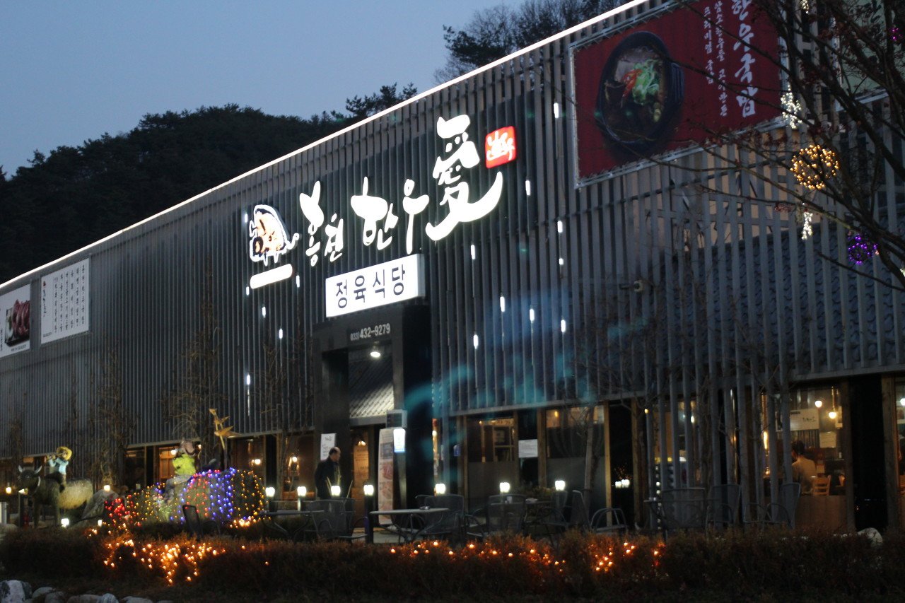 홍천한우애 부지 야간 전경 — 조명이 켜진 정육식당 건물·야외 테라스 실사진
